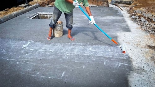 Workers applying water curing to ready mix concrete slab for crack-free and durable construction