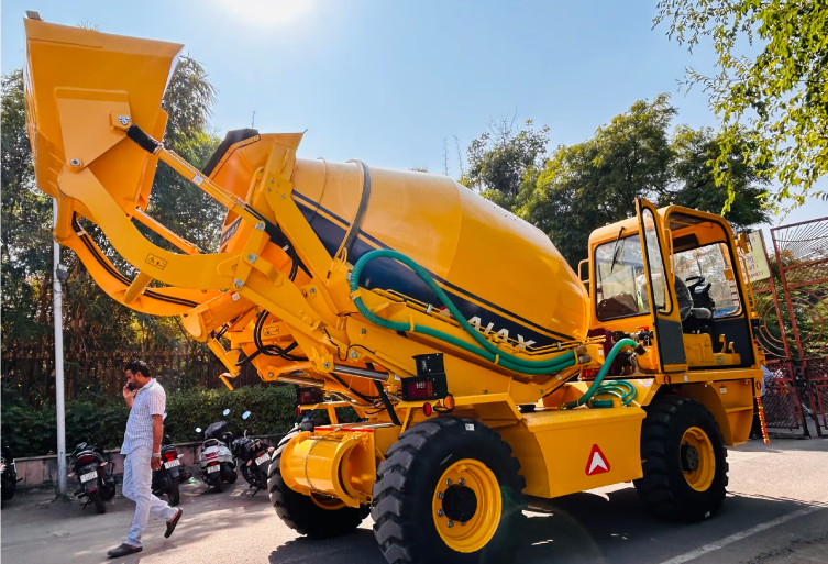 A yellow AJAX self-loading concrete mixer from Fiori Rental Services parked on an Ajmer roadside.